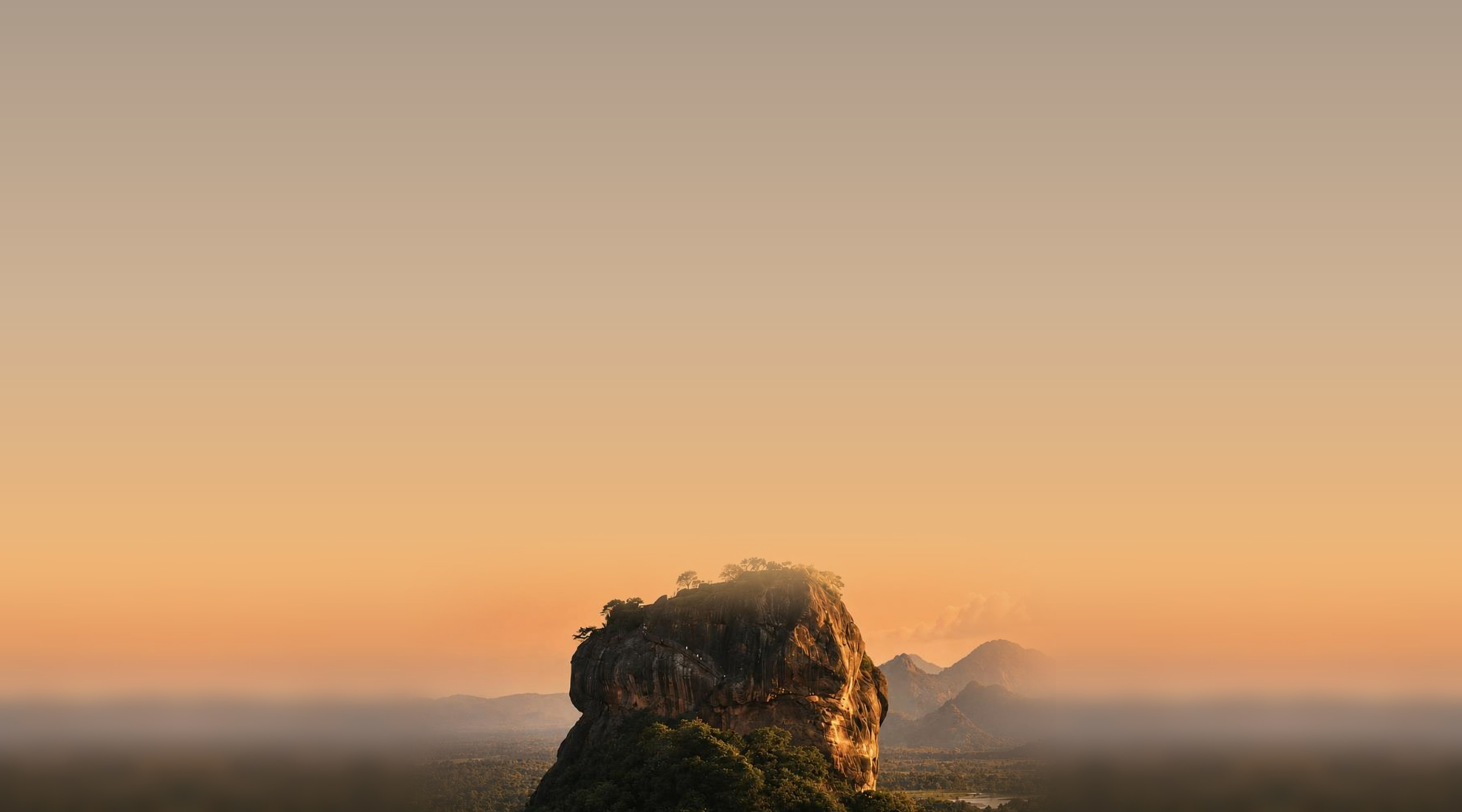Sigiriya rock fortress rising above the Sri Lankan plain at golden hour